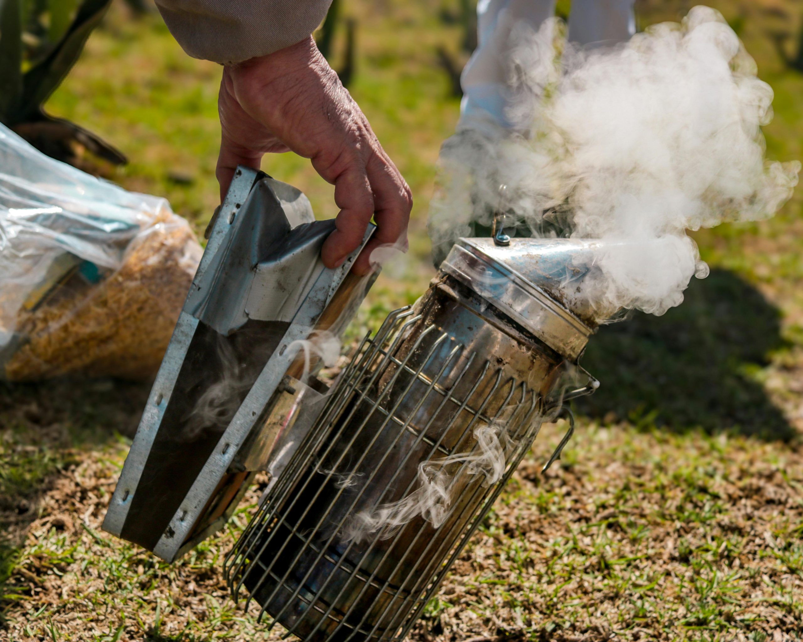 A person is holding a metal cage with smoke coming out of it
